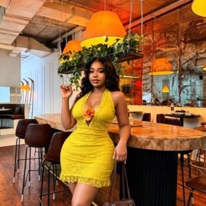 Woman wearing a yellow lace halter neck mini dress at Abuja Fashion Market